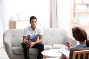 adolescent boy sitting during a therapy session learning about motivational interviewing