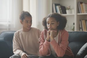 teen girl consoles an upset teen girl and representing peer support