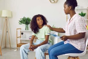 an adult woman sits with a young girl discussing impulse control disorder treatment