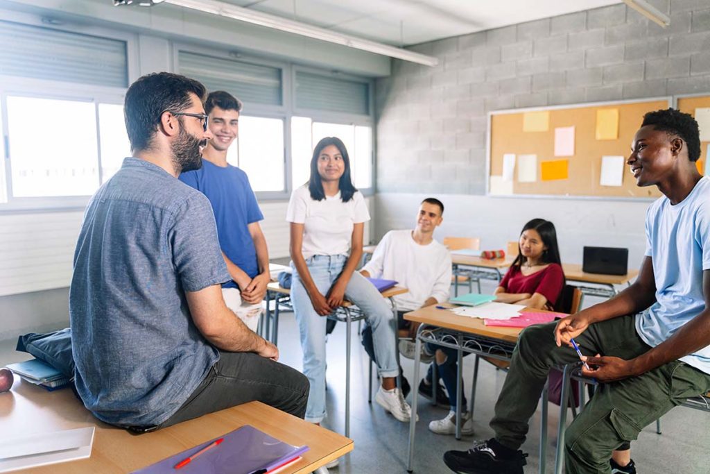 a group of teens sit in a group therapy sessions discussing group therapy activities to participate in