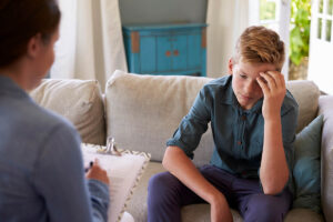 Teen hides head as he considers CBT for depression