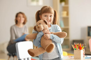 Girl hugs teddy bear while in residential treatment for kids