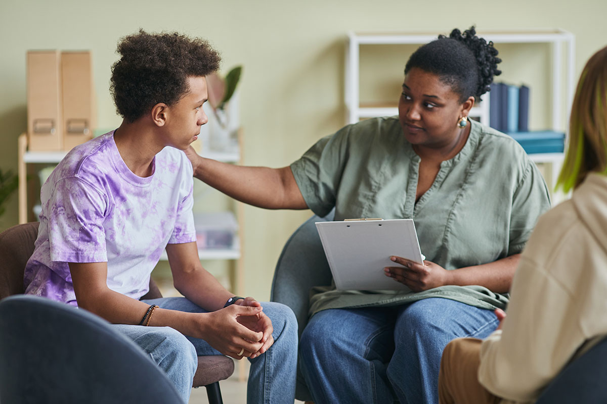 female behavioral health specialist consoles adolescent male by explaining what is a partial hospitalization program