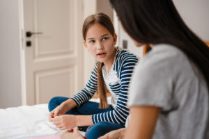 Mother talks to young daughter as she struggles to learn how to help your daughter through depression